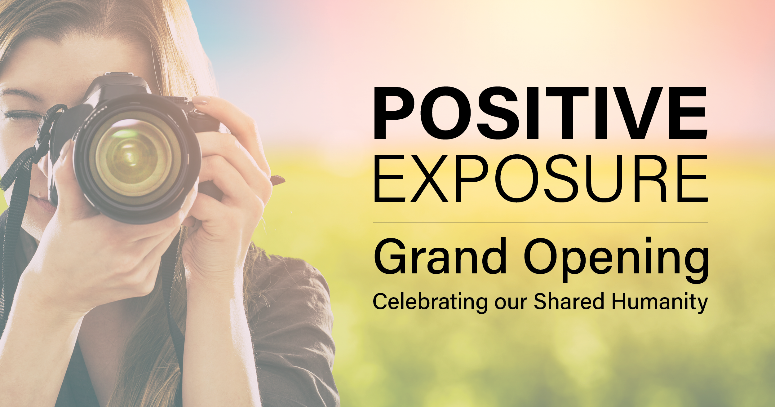 Woman with camera and text 'POSITIVE EXPOSURE Grand Opening Celebrating our Shared Humanity' on a blurred outdoor background.